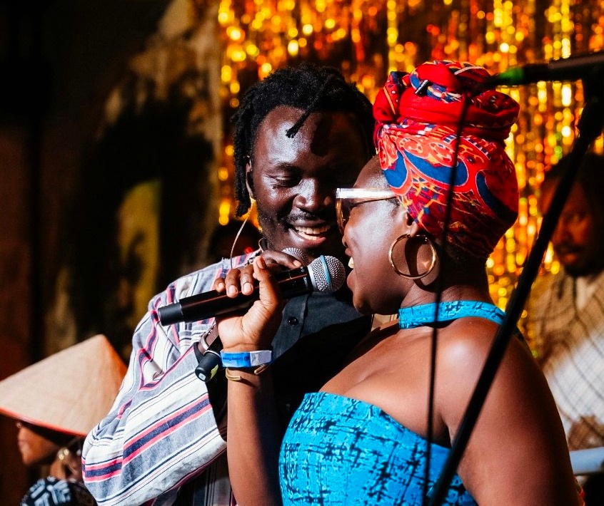Two singers sharing a microphone on stage